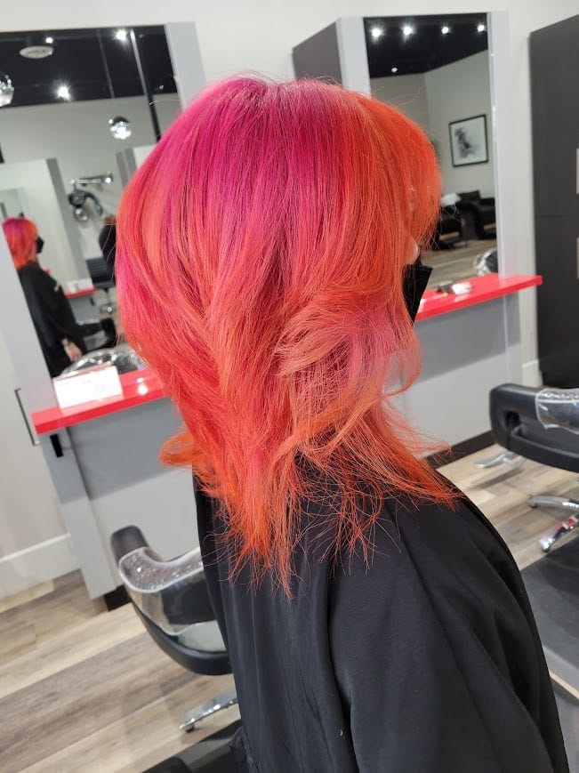 Vivid magenta-to-copper fashion color melted through a layered mid-length cut