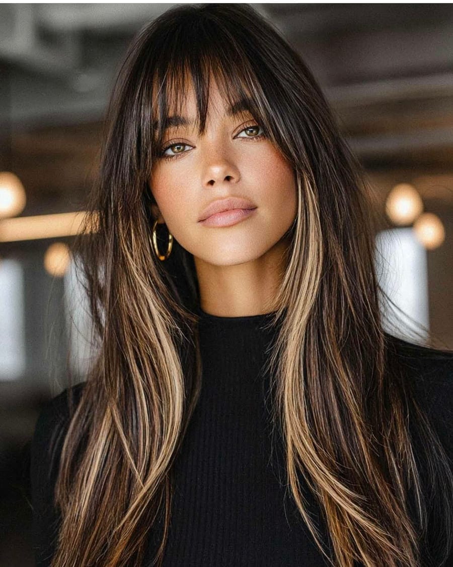 Face-framing highlights brightening the front of a long layered cut