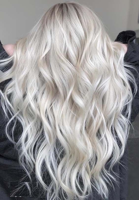 Bright, evenly toned platinum blonde through long waved hair