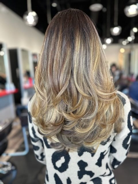 Long blonde hair finished in a soft wave blowout